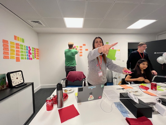 Facilitating a session, pointing people at the next activity on the wall.